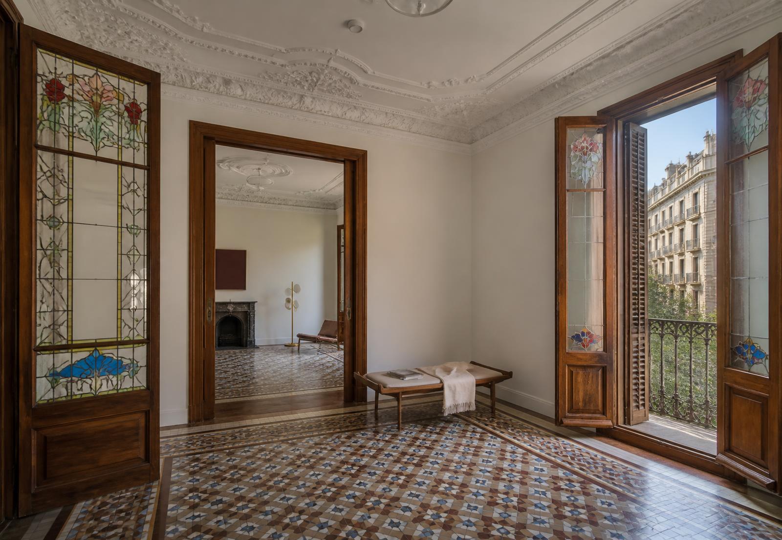 Interior modernista del Piso Consell de Cent con mosaico, molduras y vidrieras